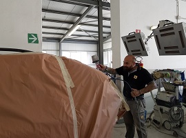 Immagine di un carrozziere in fase di verniciatura